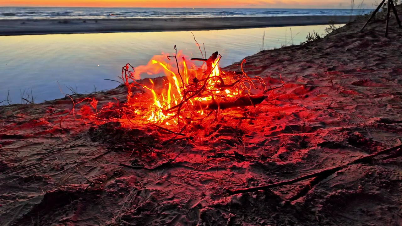 Falò romantico sulla spiaggia durante un bellissimo tramonto a Užava, Ventspils, Lettonia
