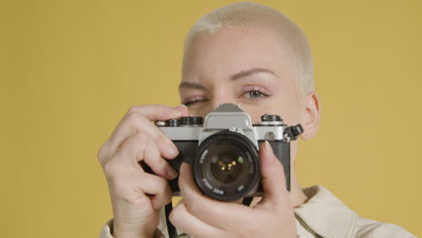 cu mujer sonriente toma fotografías en cámara vintage