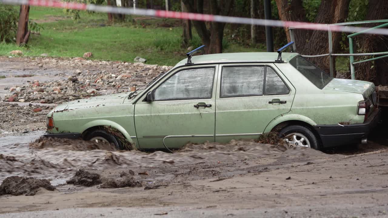 un coche atrapado en un río durante una inundación.