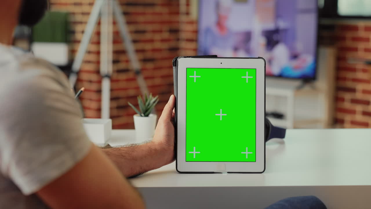 Employee analyzing greenscreen on modern tablet at home