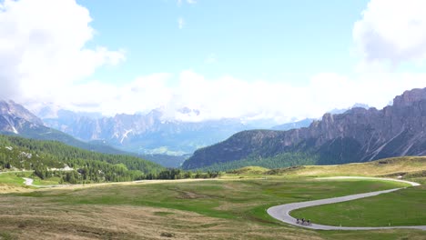 panning shot of giau pass revealing some cyclists and monte nuvolau