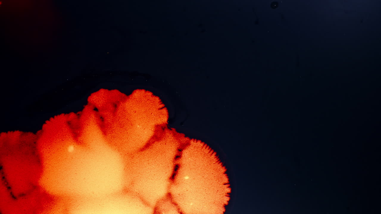 Colorful ink dissolves in liquid, creating a vibrant abstract effect