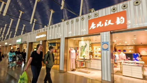 people walking past stores in airport terminal