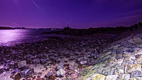 Nighttime-time-lapse-of-the-tide-rising-along-a-rocky-coastline