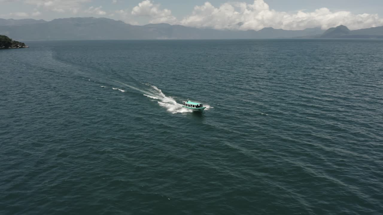 пассажирская лодка быстро плывет к вулкану сан-педро на озере атитлан, гватемала