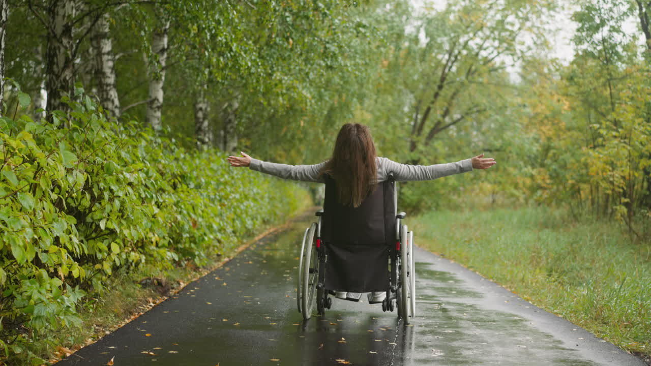mulher com lesão na medula espinhal estende os braços apreciando a caminhada