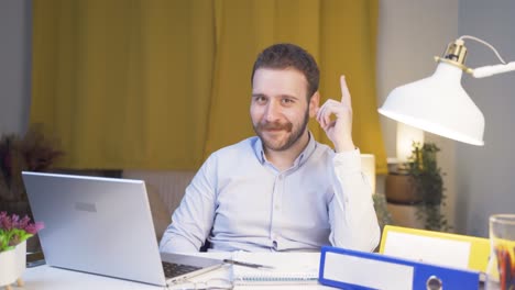 home office worker man coming up with idea looking at camera.