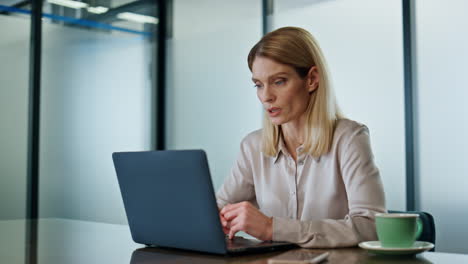 serious businesswoman calling laptop at conference room. focused woman talking