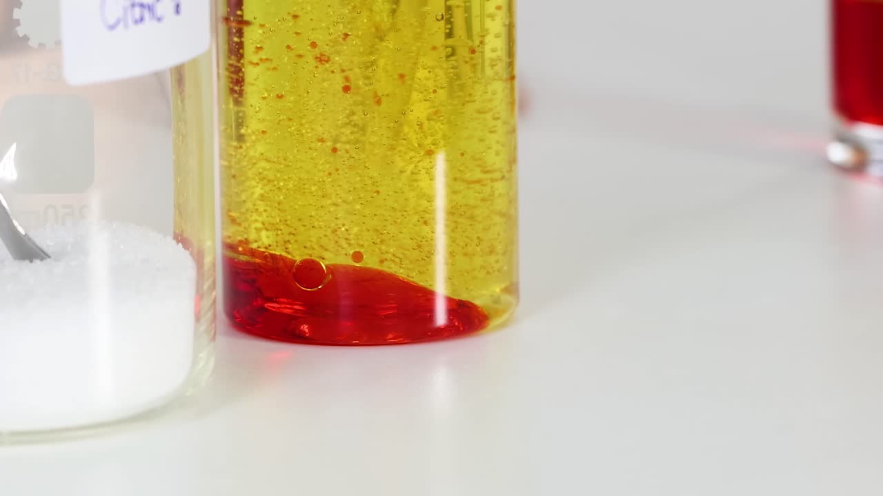 Observe vibrant liquid layers and bubbles in glass beakers, showcasing density and separation.