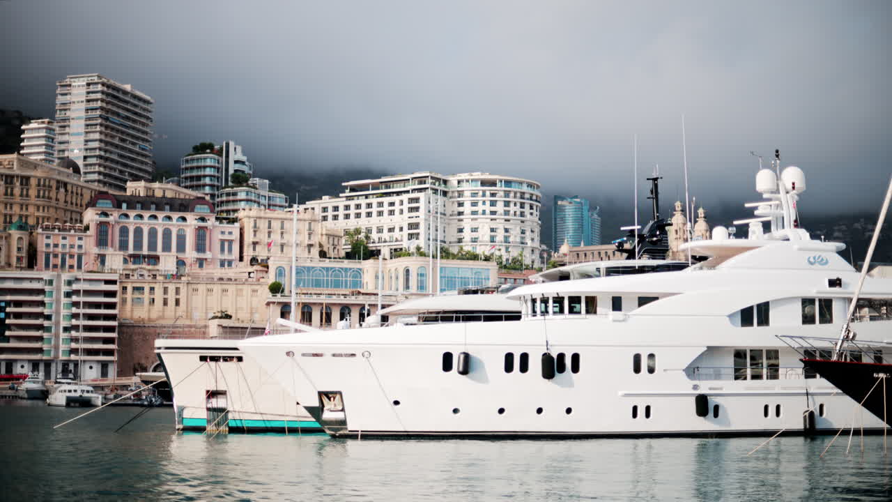 View of boats docked in the Monaco Marina with the skyline of the city on the background