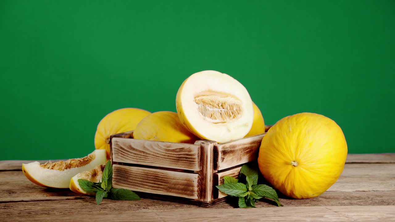 나무 상자 안의 잎이 있는 익은 멜론이 천천히 회전합니다.