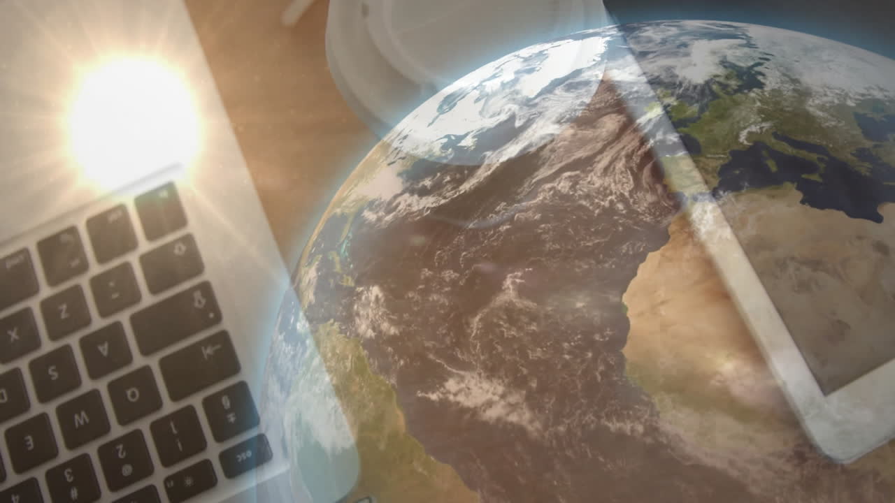 3D Earth globe floating over office workspace, blending laptop keyboard and tablet with lens flare