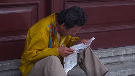 a cuban man reads a newspaper on the streets of havana