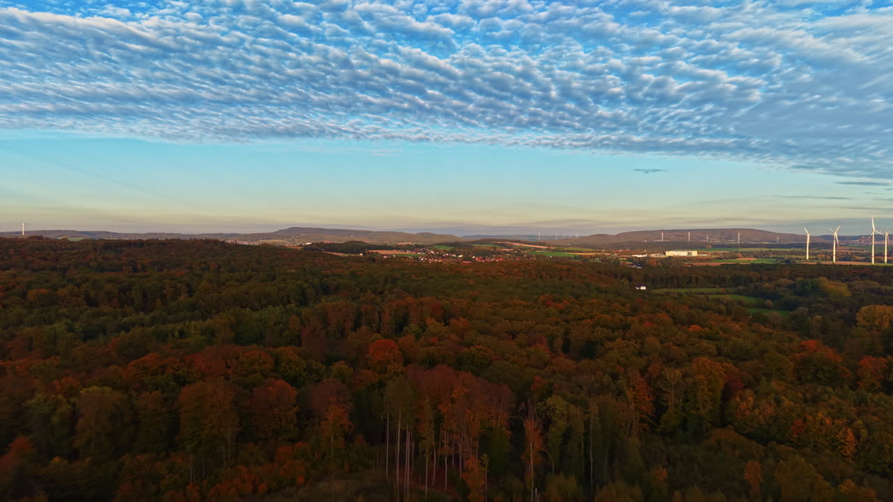 Golden hues of autumn skies above vibrant forest landscape at dusk showcasing natures beauty in transition