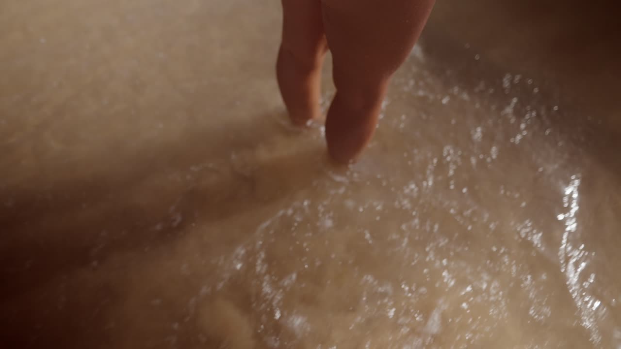 Close-up of feet and hands in water