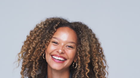 Head-And-Shoulders-Studio-Shot-Of-Woman-Wearing-Leather-Jacket-Smiling-At-Camera-In-Slow-Motion