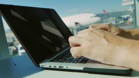 a man typing on a laptop keyboard