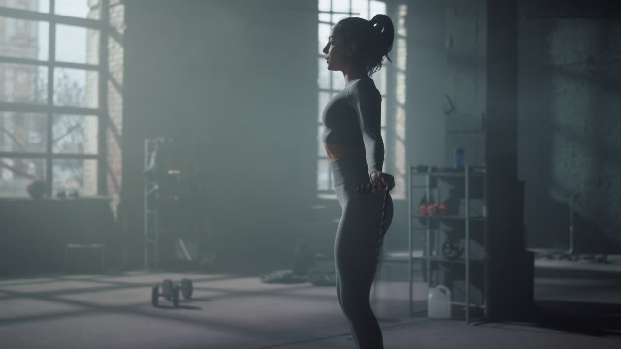 Deportista saltando la cuerda en el gimnasio. Mujer en forma realizando entrenamiento de cardio.
