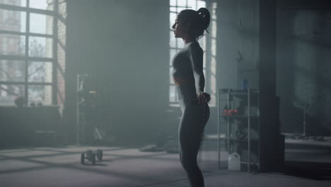 sportswoman jumping on skipping rope in gym. fit woman doing cardio workout