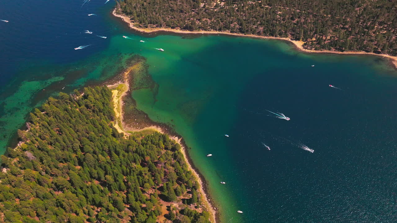 Boats sailing through the isthmus between the wooded shores. Sunny day footage over the splendid scenery from air.