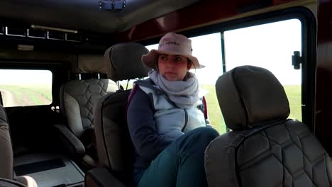 mujer joven en safari viajando en un jeep 4x4, mirando y sonriendo a la cámara, disfrutando de la luna de miel