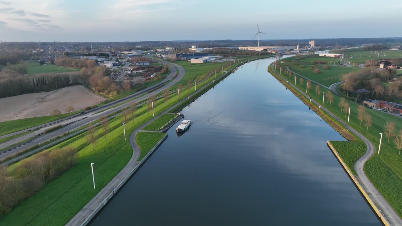 Aerial zoom out showing a boat navigating the canal near the Strépy-Thieu boat lift in Le Roeulx during golden hour