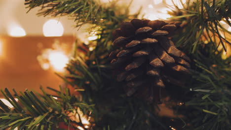 hand of woman decorating christmas tree with christmas glow lights.