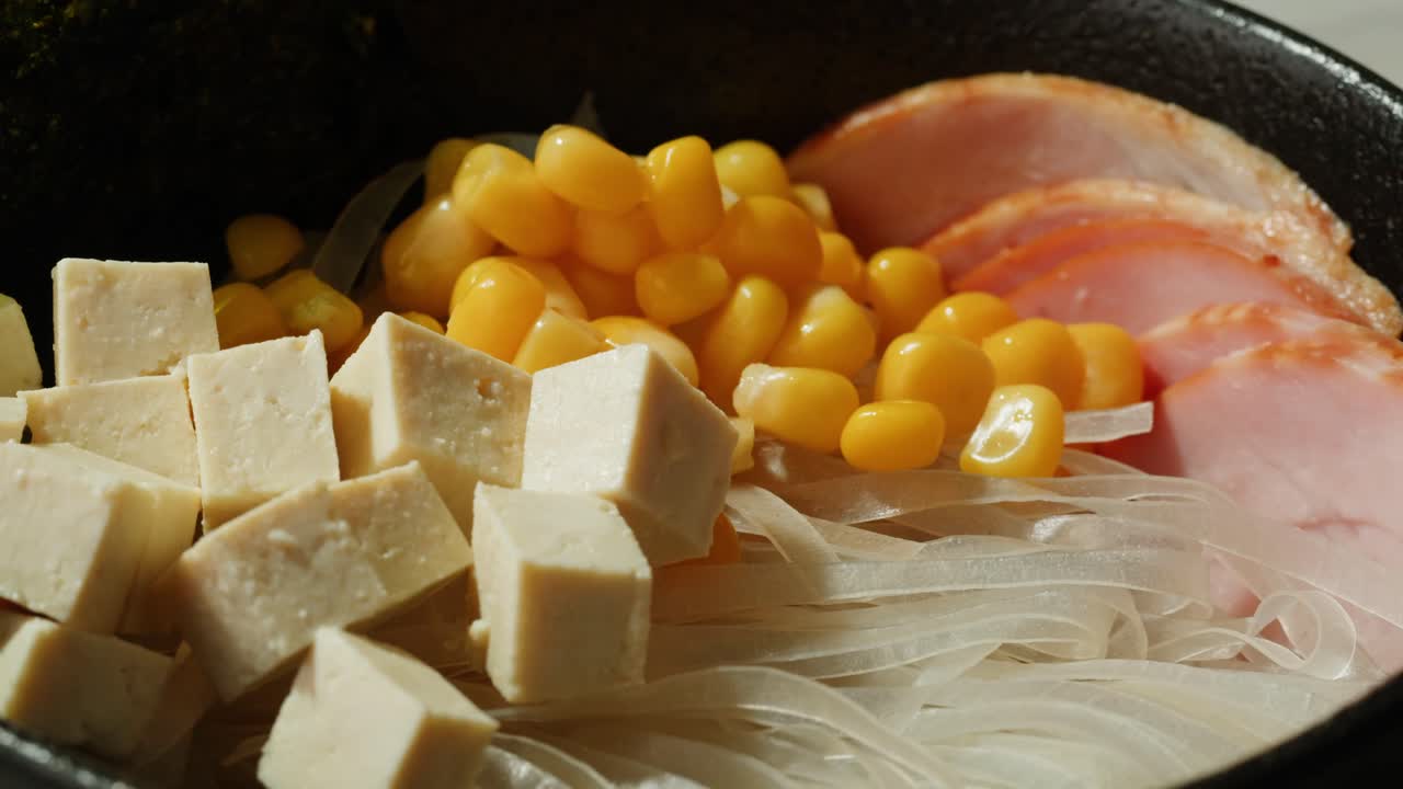 토푸, 옥수수, 햄, 봄 양파 를 들인 맛있는 아시아 라면 그 을 준비 하고 있다