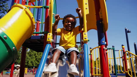 happy young boy enjoying a slide at the playground