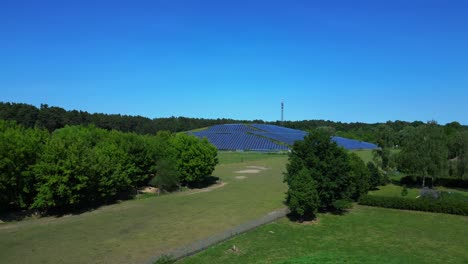 photovoltaic panels installed on a former landfill, transforming a waste site into a source of renewable energy, a solution for the future. dramatic aerial view flight descending drone