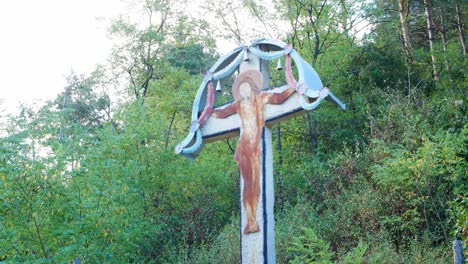 tilt up shot of an orthodox catholic cross in the middle of the forest