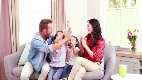 Glückliche-Familie,-Die-Die-Arme-Hebt-Und-Ein-High-Five-Macht