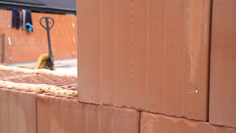 Large ceramic block placed on adhesive foam layer during wall construction