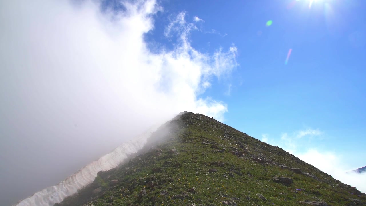 Nubes moviéndose sobre una cresta de montaña cubierta de hierba