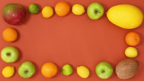 tropic summer frame made of exotic fruits on orange background. stop motion