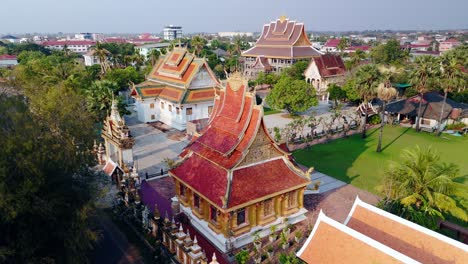 Pagoda-Tradicional-Con-Techo-Arqueado-En-La-Ciudad-De-Laoation,-Savannakhet,-Rotación-Aérea-De-Drones-Durante