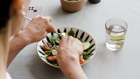person eating a healthy salad with water