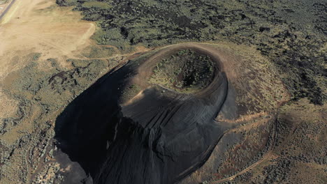 drone aerial view, inactive volcanic caldera and crater cinder cone hiking trail in snow canyon state park, utah usa