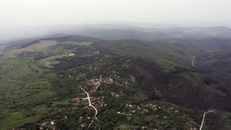 Die-Drohne-Zieht-Sich-Langsam-Zurück,-Während-Sie-über-Dem-Dorf-Tsarichina-Fliegt,-Das-Für-Seine-Außerirdischen-Sichtungen-Bekannt-Ist-Und-Die-Weite-Des-Strandzha-Gebirges-In-Bulgarien-Zeigt