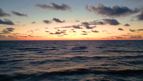 Tropical-golden-sunset-over-ocean-water-slow-motion-aerial-view