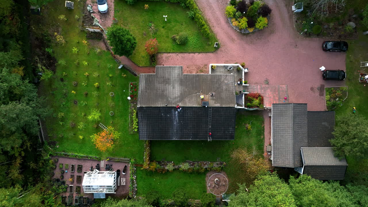 Aerial View of People Pressure Washing a House Roof