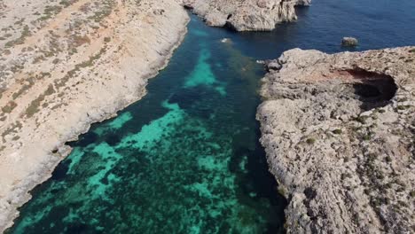 Vista-De-Drones-En-Hermosos-Paisajes,-Entrada-Rodeada-De-Acantilados,-De-La-Laguna-Azul-De-Comino,-Malta,-Mar-Mediterráneo