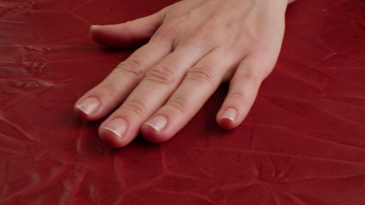 Mano su sfondo rosso