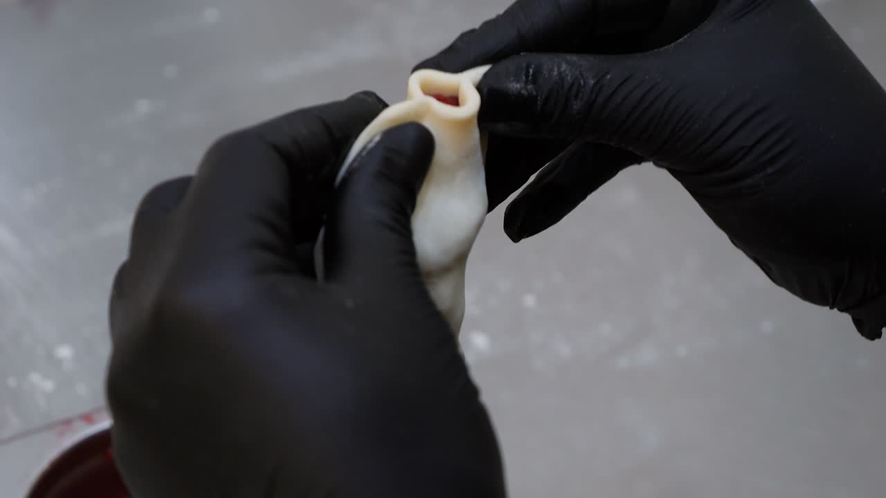 el chef da forma a un pierogi de fresa usando sus manos