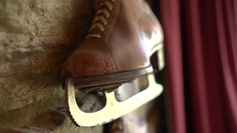 slowmo - old brown leather antique ice skating shoe on historic wall