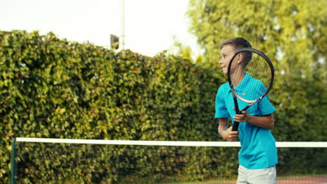 teen boy with racket training on outdoor tennis court on a summer day 1