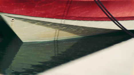 sunlight glimmers and reflects across water onto bow of boat, cinematic closeup