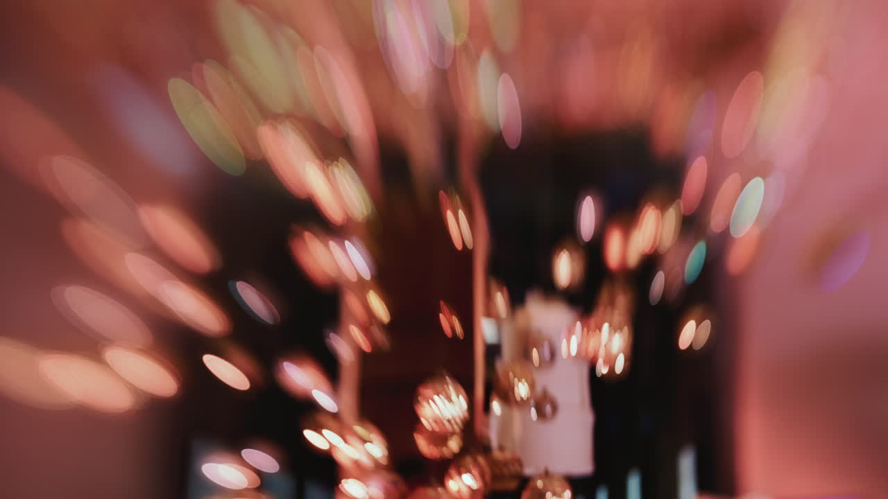 Scatto astratto di luci natalizie dai toni caldi e decorazioni sospese, sfocato per creare un effetto bokeh festivo