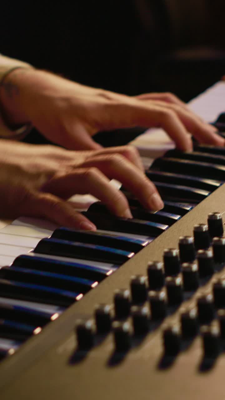 Hands Playing Keyboard and Operating Mixing Console in Music Studio