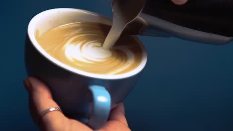 smooth coffee pour into a blue cafe cup